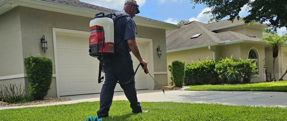 Crew spraying a lawn in New Smyrna Beach, FL, with weed control treatments.