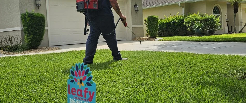 Crew treating grass in New Smyrna Beach, FL, with fertilizer.
