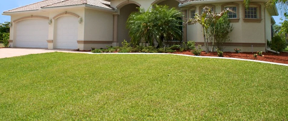 Green, weed-free lawn in New Smyrna Beach, FL, and a house.
