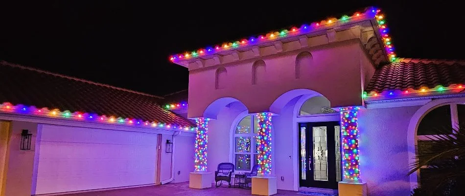 House with columns in New Smyrna Beach, FL, with colored holiday lights.