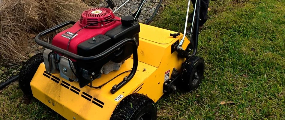 Lawn in New Smyrna Beach, FL, with yellow aerator machine.