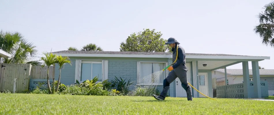 Man applying a liquid fertilizer treatment on a lawn in New Smyrna Beach, FL.