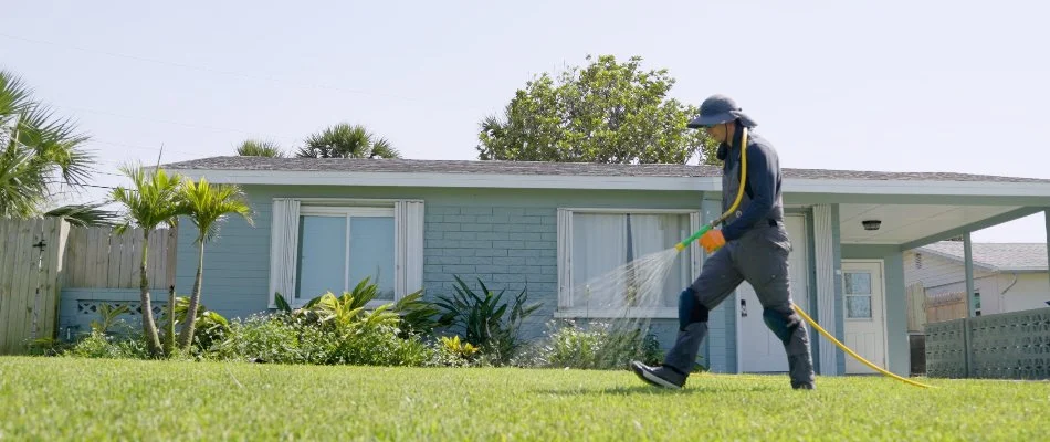 Man applying a weed control treatment on a lawn in New Smyrna Beach, FL.