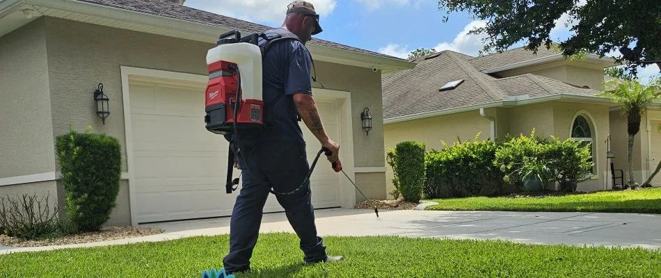 Man spraying weed control treatment on a lawn in New Smyrna Beach, FL.