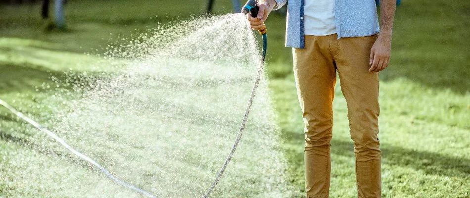Man watering a lawn in New Smyrna Beach, FL.