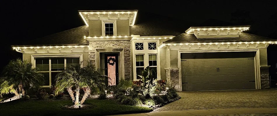 Warm white holiday lighting on house and trees in New Smyrna Beach, FL.