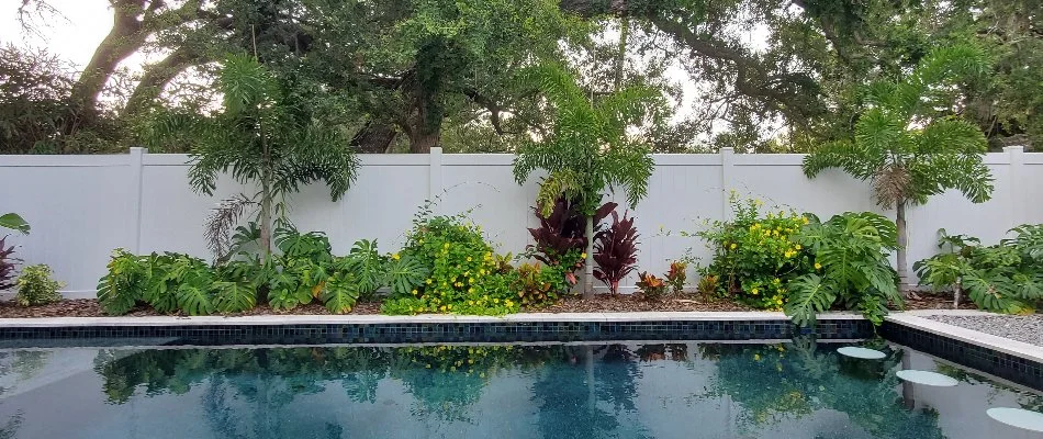 Lawn with plants near white fence on a property in New Smyrna Beach, FL.